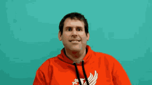 a man wearing a red hoodie with a white eagle on it