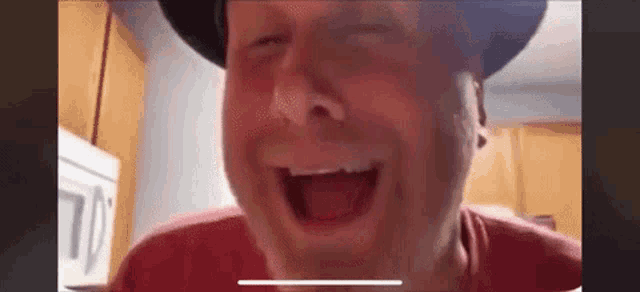a man wearing a hat is making a funny face while talking on a video call .