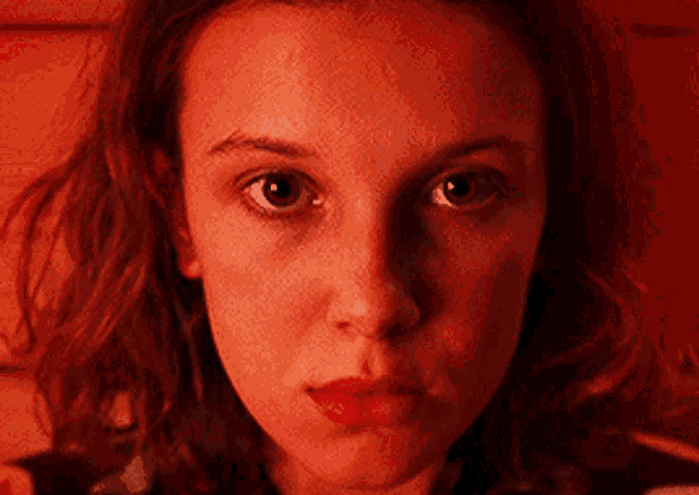 a close up of a woman 's face in a dark room