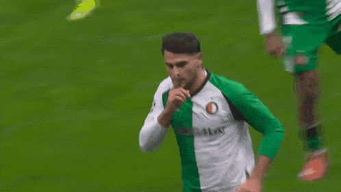 a soccer player wearing a green and white jersey with media markt written on it