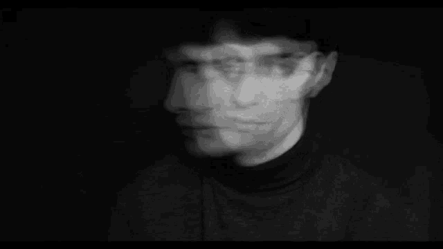 a blurry black and white photo of a man 's face