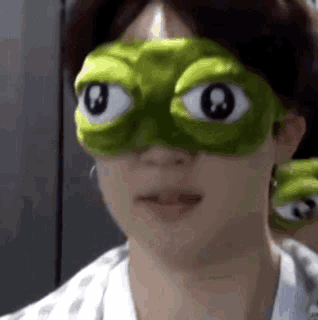 a close up of a person wearing a mask with big eyes .
