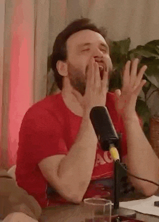 a man is yawning in front of a microphone .