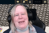a woman wearing headphones is smiling in front of a screen .