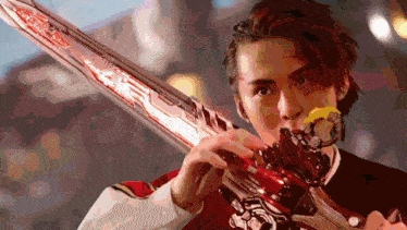a man in a red shirt is holding a red sword