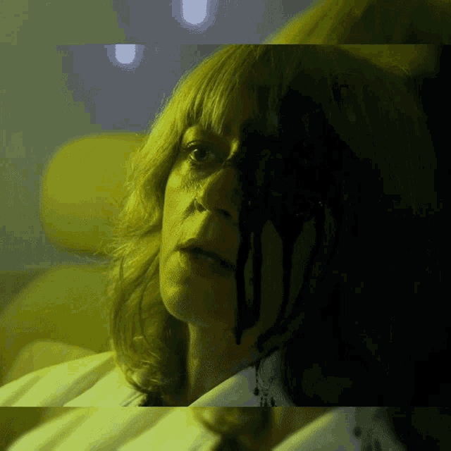 a close up of a woman 's face with blood coming out of it