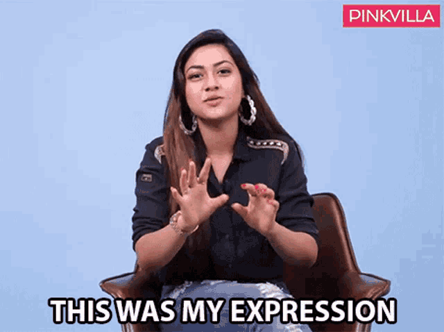 a woman is sitting in a chair and making a gesture with her hands and the words " this was my expression " below her