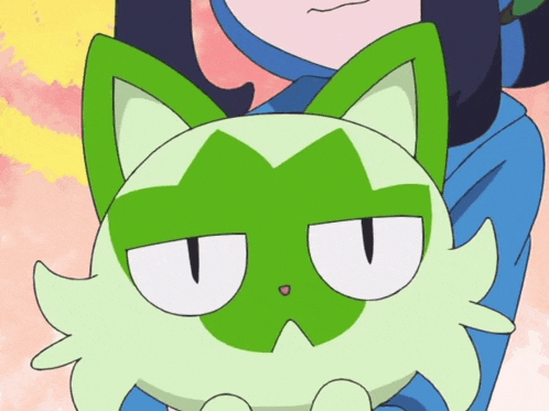 a person is holding a green cat with a white face