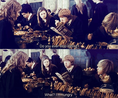 a group of harry potter characters are sitting around a table eating