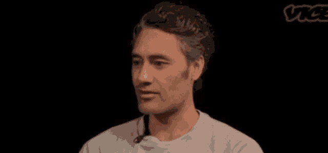 a man with a microphone on his neck is smiling in front of a vice logo