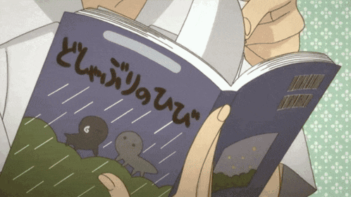 a person is reading a book with chinese writing on the cover