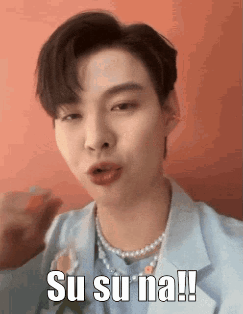 a man wearing a pearl necklace says su su na !!!