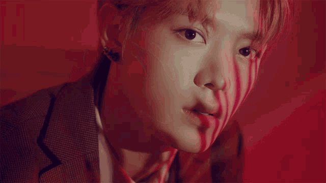 a close up of a man 's face with a red shadow on it