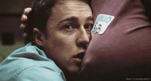 a man is hugging a boxing bag with a sticker on it that says hello .