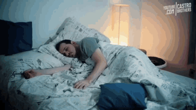 a man is sleeping on a bed with a youtube castro brothers advertisement behind him