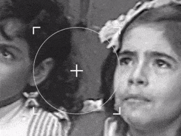 a black and white photo of a boy and a girl with a cross in the center