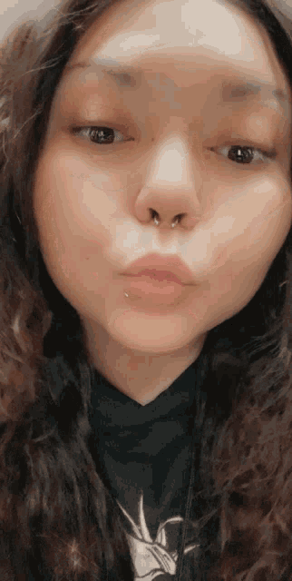 a close up of a woman 's face with a nose piercing