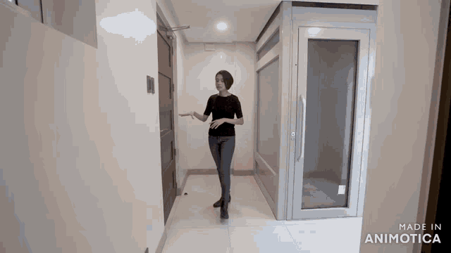 a woman standing in a hallway with the words made in animotica on the bottom right