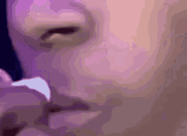 a close up of a person 's face with purple lighting