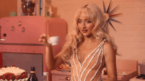 a woman in a white dress is pouring a cup of coffee