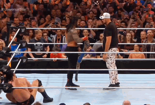 wrestlers in a ring with the words universal title on the bottom right