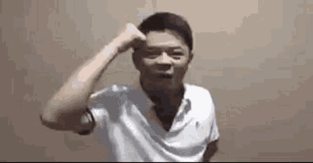 a man in a white shirt is making a funny face .