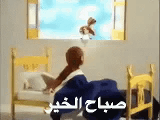 a person sitting in a chair looking out a window with arabic writing on the bottom