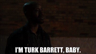 a man is standing in front of a brick wall and says `` i 'm turk barrett , baby . ''