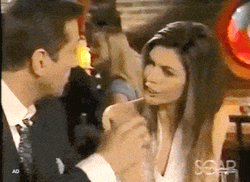 a man in a suit and tie is holding a woman 's hand in front of a sign that says ad