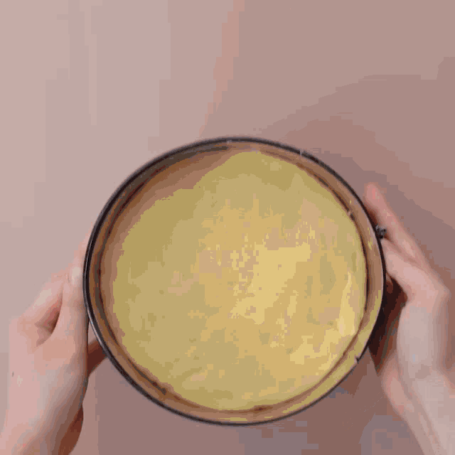 a person is putting a piece of cheese on a cake