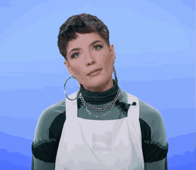 a woman wearing hoop earrings and a white apron has the letter e on her shirt
