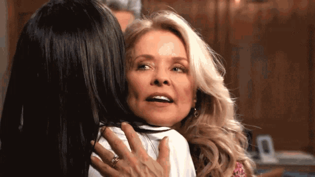 two women hugging each other with one wearing a ring