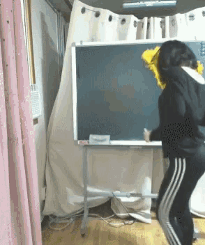 a woman is standing in front of a blackboard that says ' e ' on it