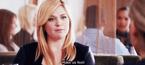 a woman is sitting at a table in a restaurant talking to a man and says `` make us feel '' .