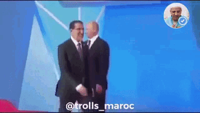 two men in suits are standing next to each other on a stage with the caption trolls_maroc