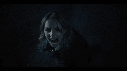 a woman in a dark room with her mouth open