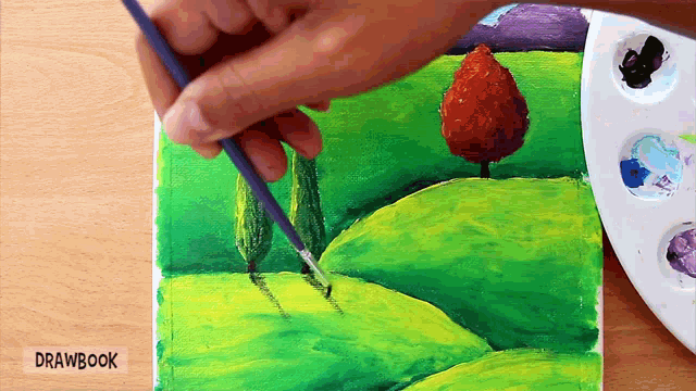 a person is painting a landscape with drawbook written on the bottom left