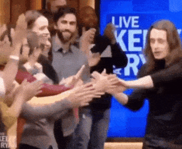 a group of people giving each other high fives in front of a screen that says " live key "