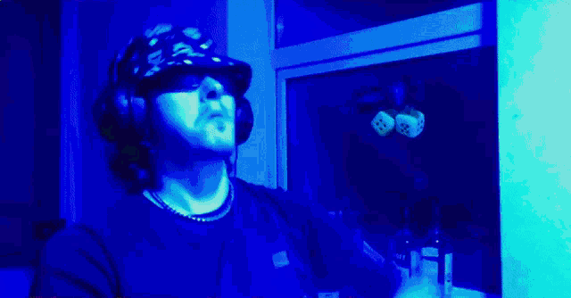 a man wearing a hat that says ' a ' on it is standing in front of a window