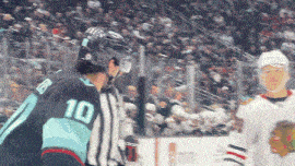 a hockey player wearing a number 10 jersey talks to a referee