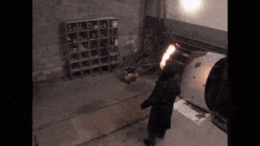 a man in a black coat is standing in a dark room with a fireball in his hand