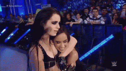 a woman is hugging another woman in front of a crowd .