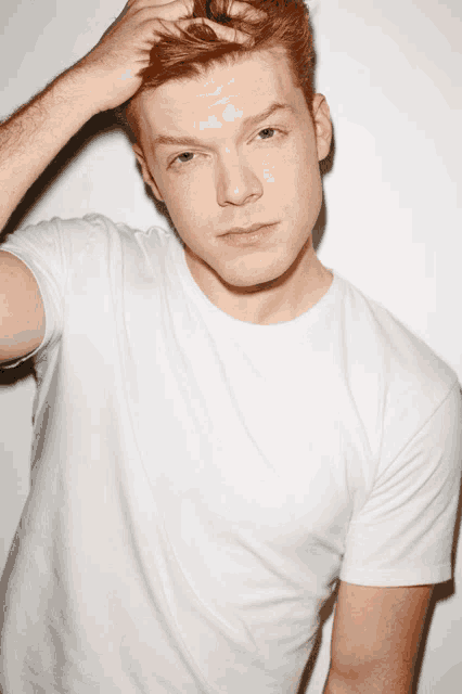 a man with red hair wearing a white t-shirt