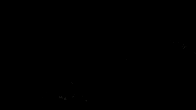 a man and a woman are standing in a dark room looking out a window