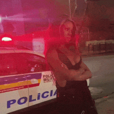 a woman is standing in front of a police vehicle