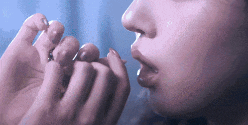 a close up of a woman applying lipstick to her lips