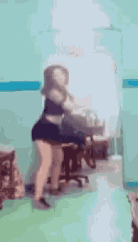 a woman is dancing in front of a mirror in a room with a green floor .