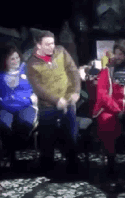 a blurry picture of a man in a yellow jacket dancing