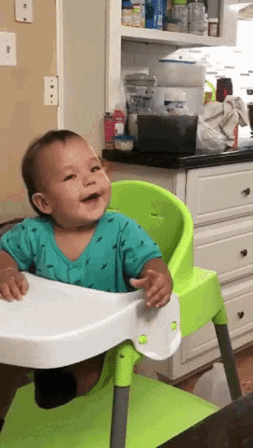 a baby is sitting in a high chair and smiling