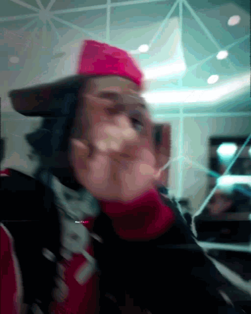 a blurry picture of a man wearing a red hat and a black jacket